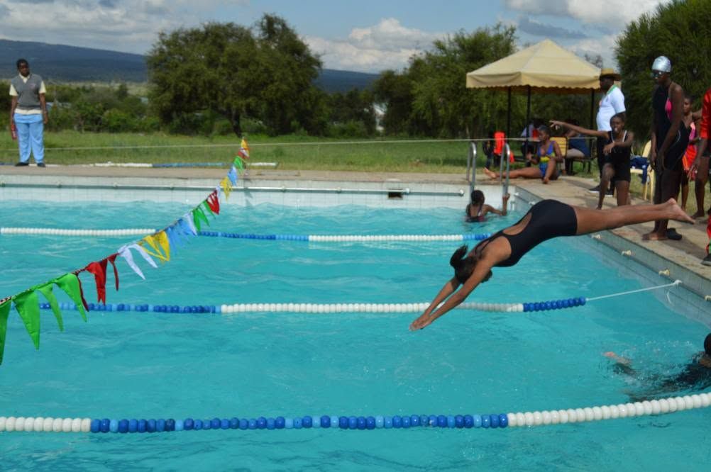 A swimmer diving at a competition